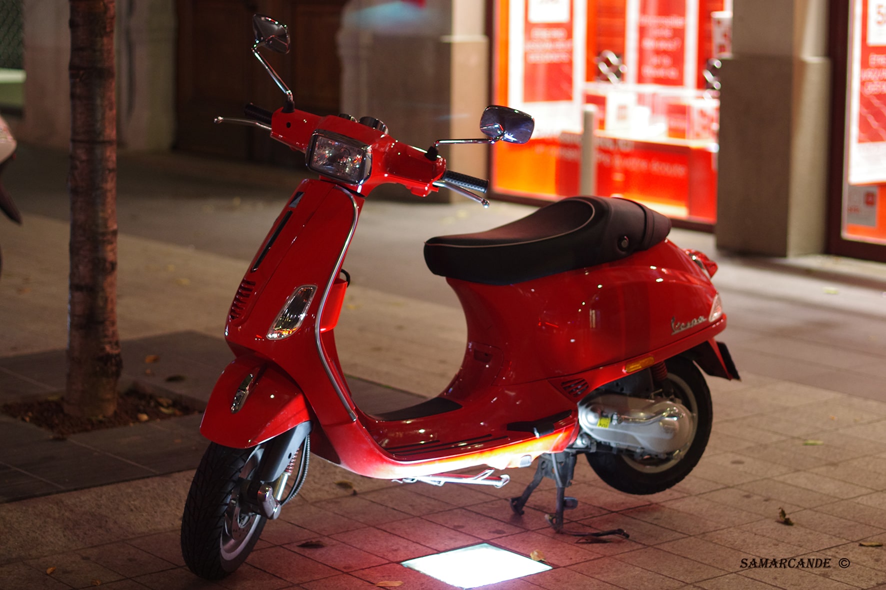 Scooter rouge dans un environnement urbain de nuit